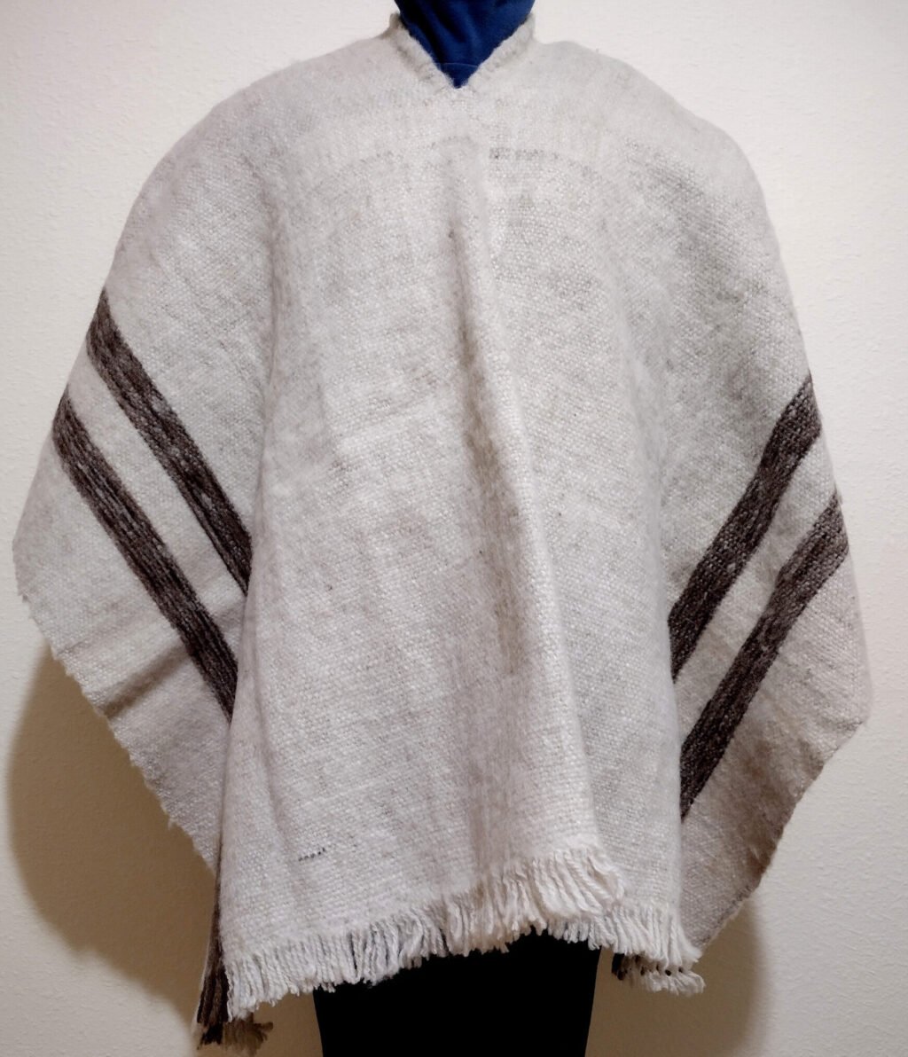 White pure wool poncho with 4 vertical dark colored stripes.