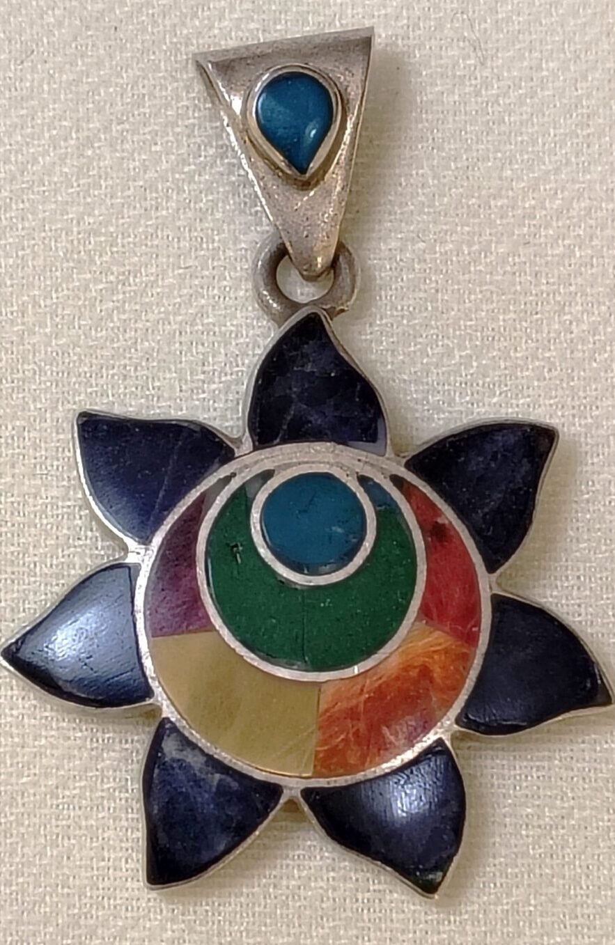 Silver sun pendant with shell and gemstone inlay with all the colors of the rainbow.